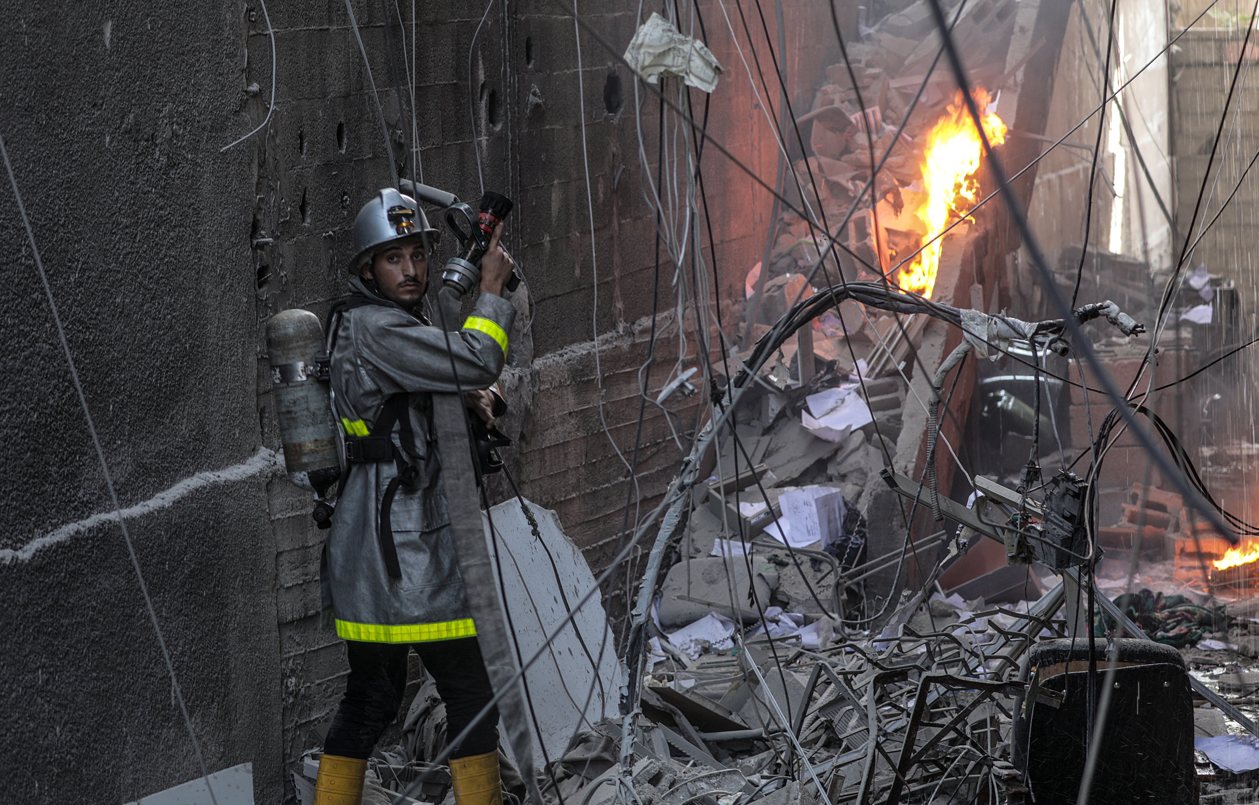 Uno de los bomberos sofoca el fuego tras el ataque.