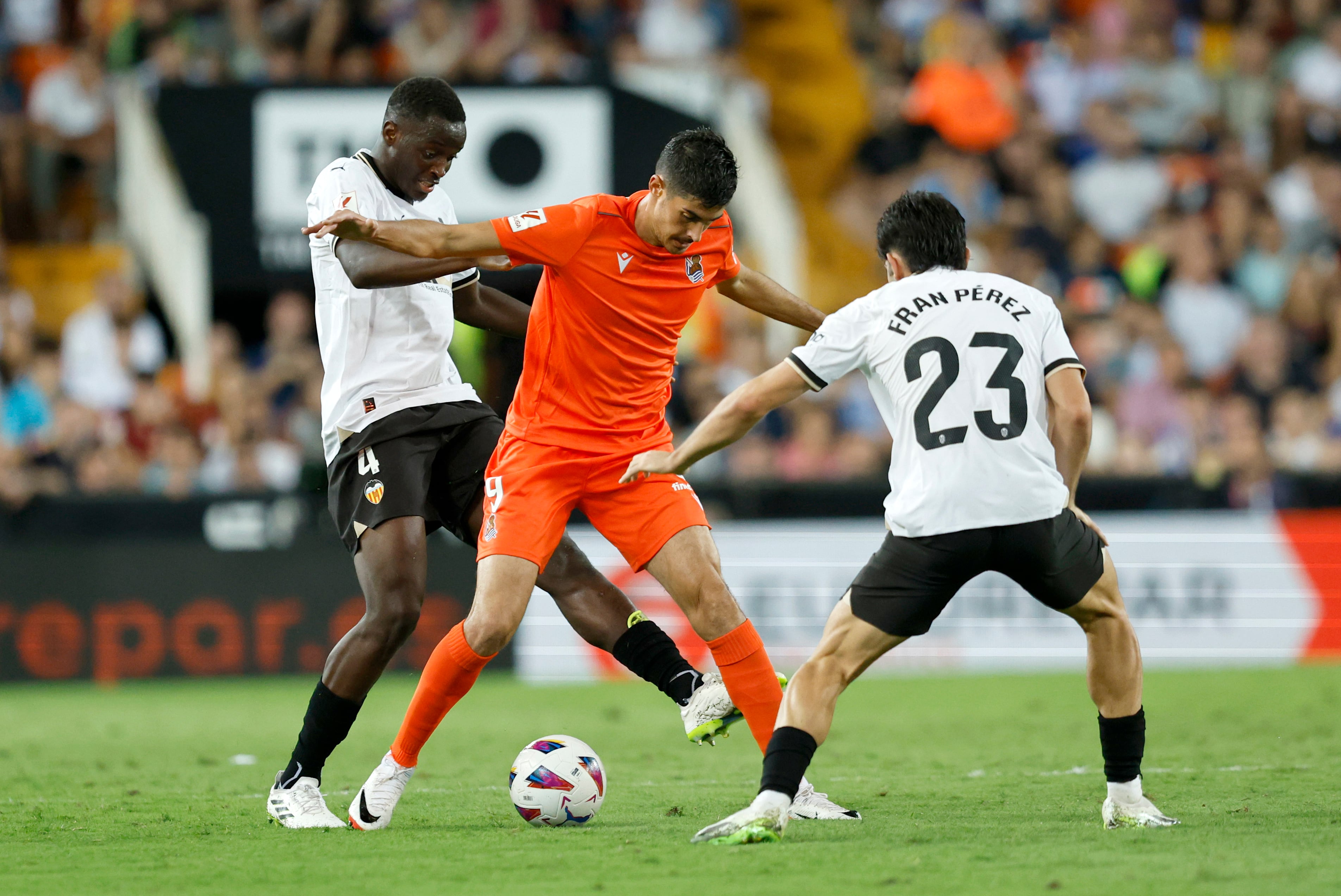 VALENCIA, 27/09/2023.- El delantero de la Real Sociedad Carlos Fernández (c) protege un balón ante Fran Pérez, del Valencia, durante el encuentro de la jornada 7 de LaLiga EA Sports entre Valencia CF y Real Sociedad, este miércoles en el estadio de Mestalla en Valencia. EFE/ Biel Aliño
