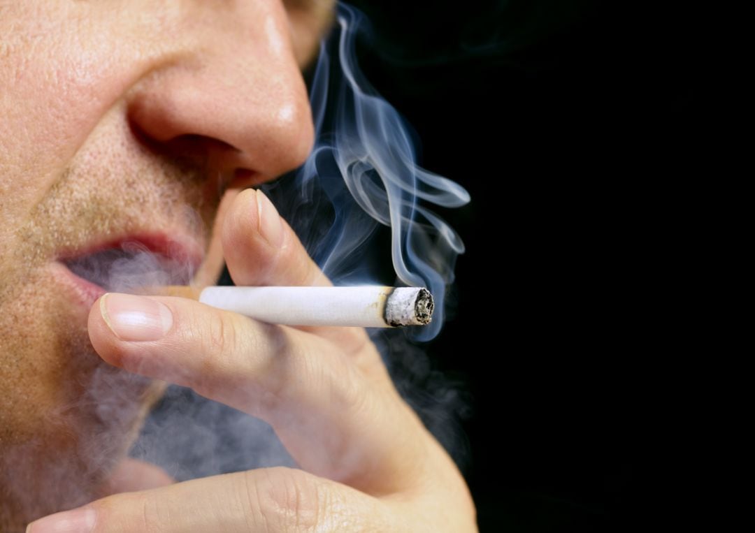 Imagen de archivo de un hombre fumando un cigarro