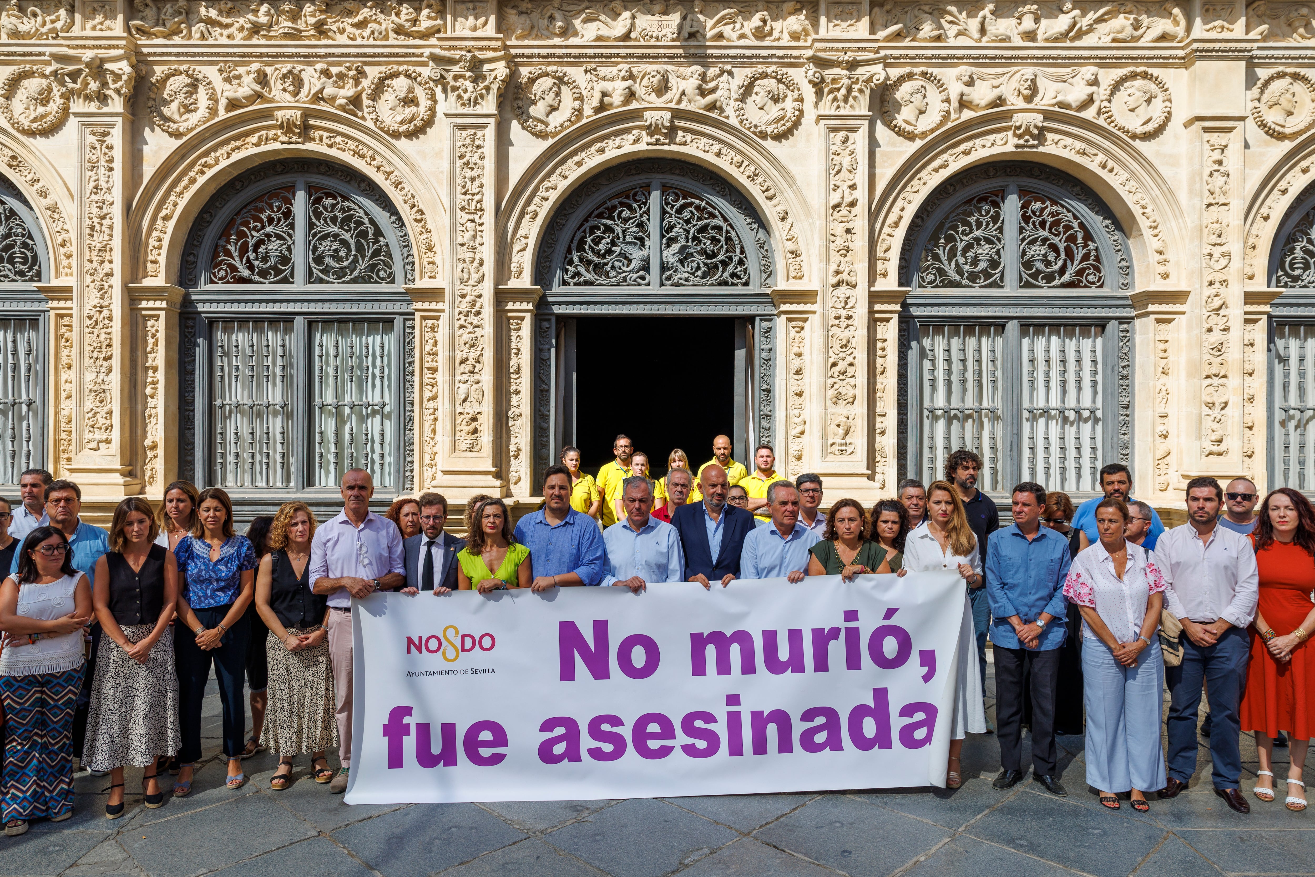 SEVILLA, 29/08/2024.- El alcalde de Sevilla, José Luis Sanz (c), junto a miembros de la Corporación Municipal, autoridades, agentes sociales y trabajadores municipales, durante el minuto de silencio convocado este jueves ante el Ayuntamiento hispalense donde se ha leído un comunicado en repulsa por el último asesinato de una mujer de 58 años ayer en la ciudad de Sevilla. EFE/ Julio Muñoz
