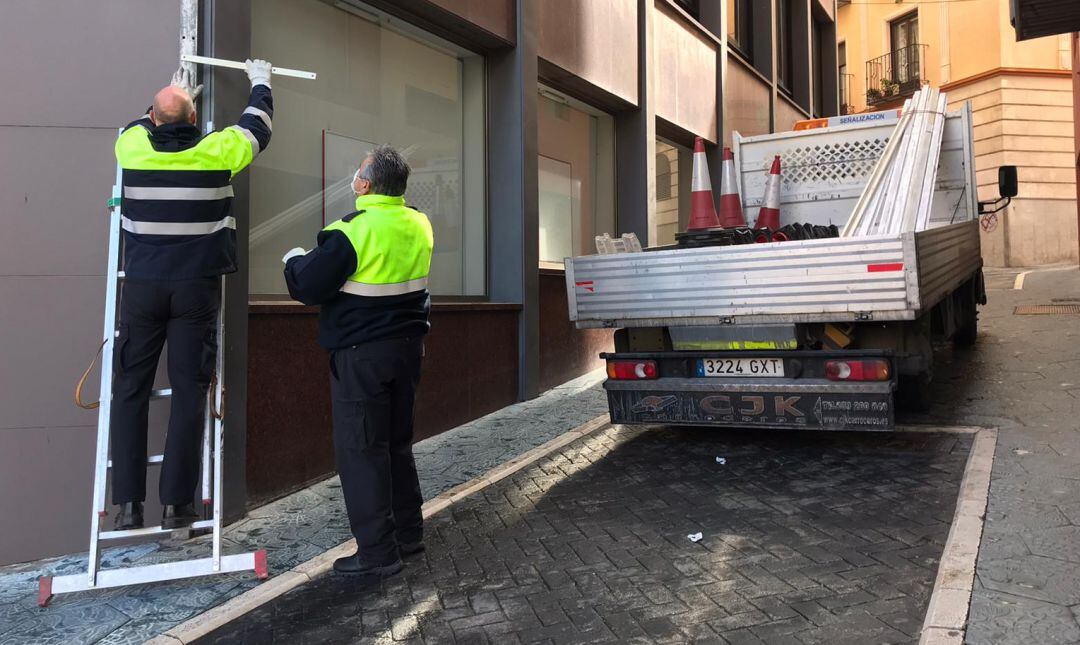 Dos operarios municipales cambian una señal de tráfico en las cercanías de la calle Tablerón.