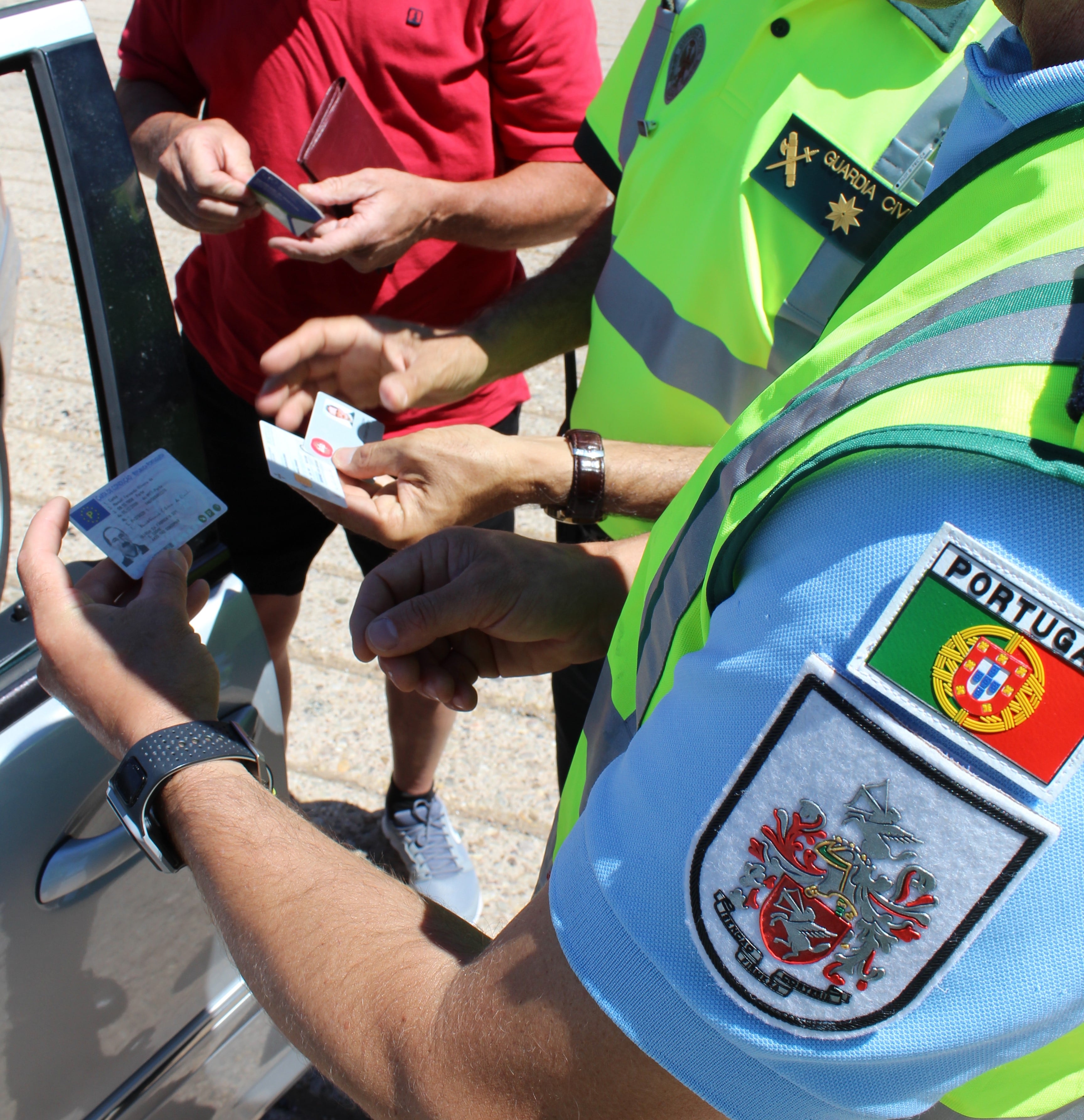 Agentes de la Guardia Civil y Guardia Nacional Republica (GNR) de Portugal inspeccionando unos carnets falsos.