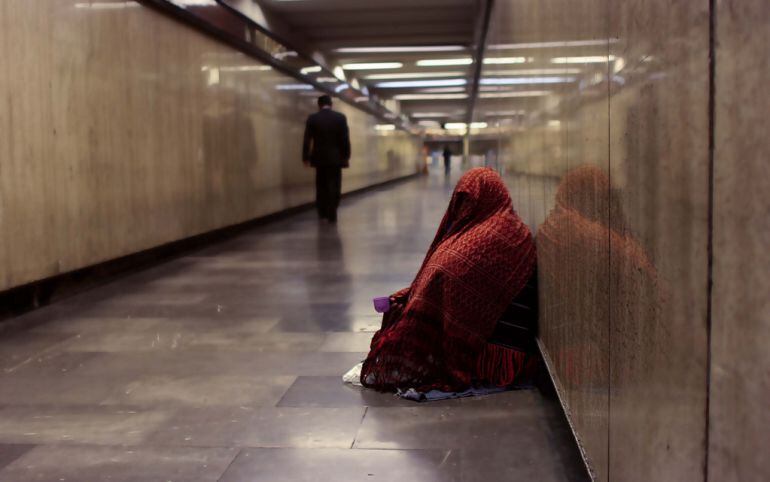 Una mujer pide dinero.