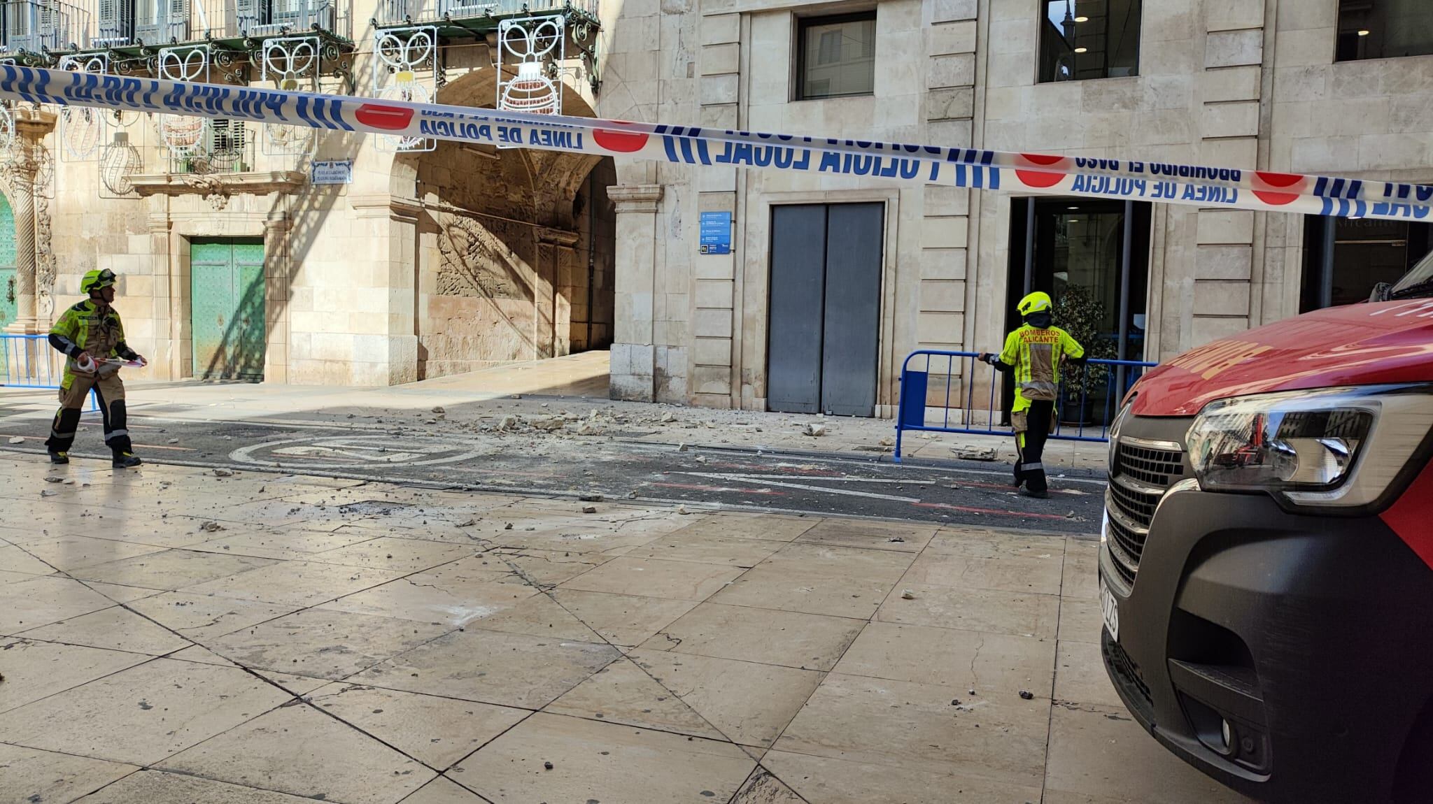 Cascotes en la calzada tras el desprendimiento de una parte de la cornisa de la torre del reloj del Ayuntamiento de Alicante