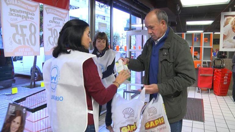 El Banco de Alimentos ha iniciado la gran recogida solidaria. Un vigués dona en el supermercado Gadis alimentos no perecederos