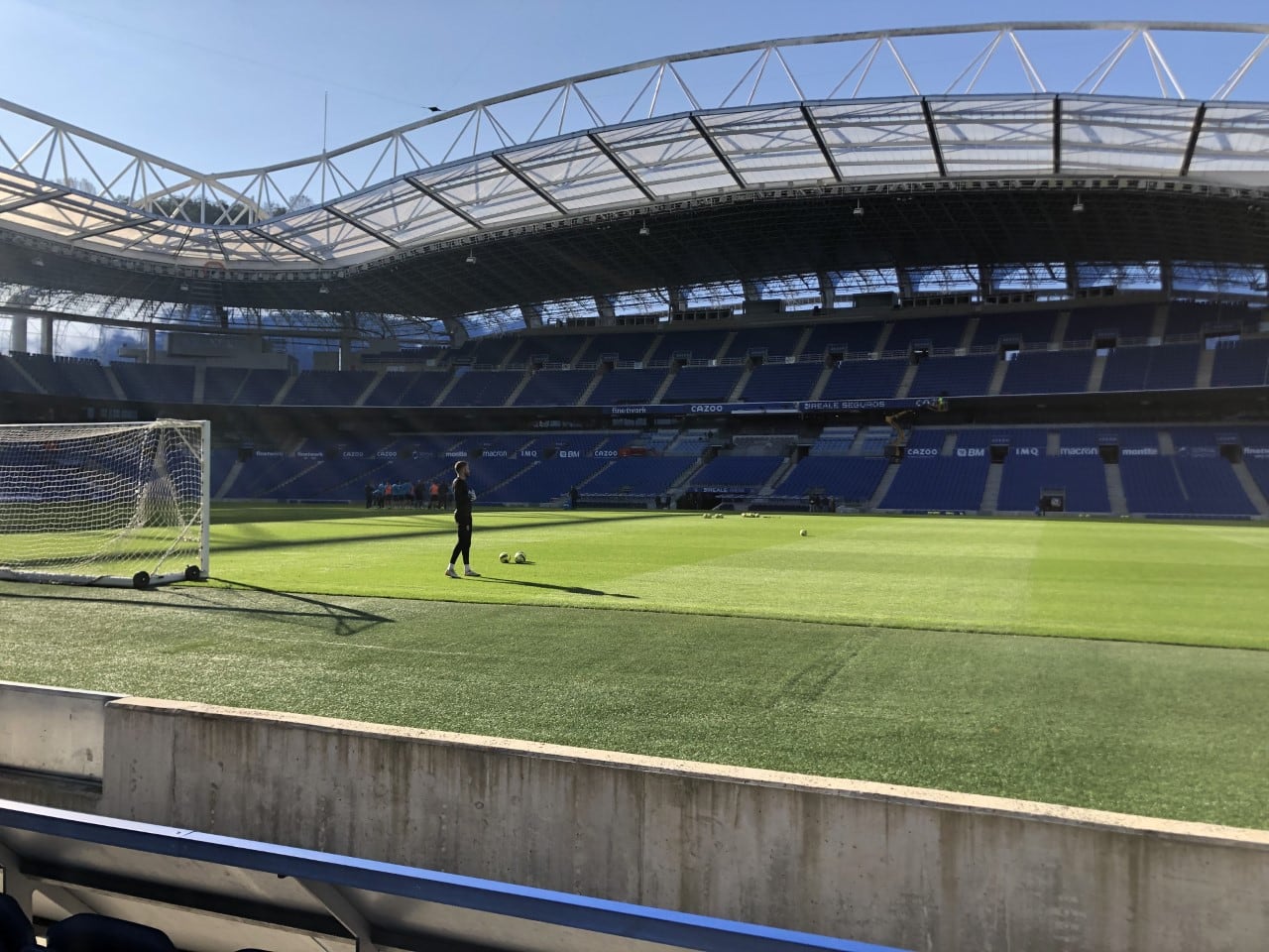 Remiro en primer plano se ejercita mientras sus compañeros escuchan a Imanol