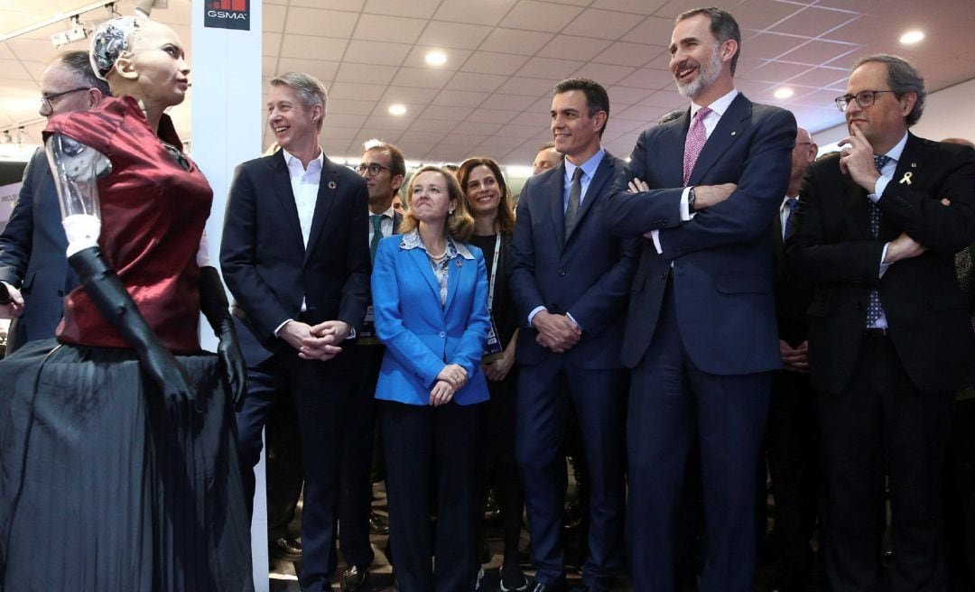 El rey Felipe VI, junto al presidente del Gobierno, Pedro Sánchez (3d), y el presidente de la Generalitat, Quim Torra (d), interactúa con la robot Sophia.