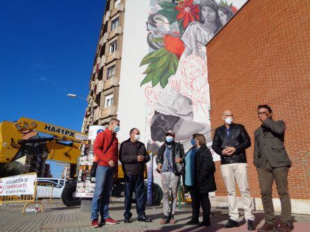 La autora del mural, tercera por la izquierda, con responsables de las asociaciones de comerciantes y vecinos del berrio, y el artista arandino Namo Lázaro (a la dcha)