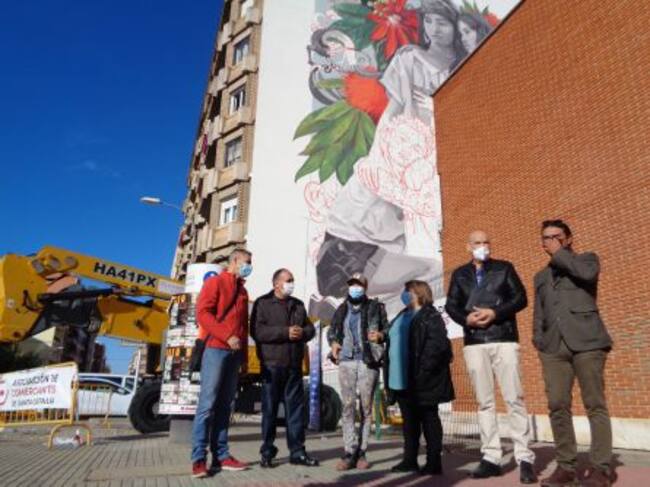 La autora del mural, tercera por la izquierda, con responsables de las asociaciones de comerciantes y vecinos del berrio, y el artista arandino Namo Lázaro (a la dcha)