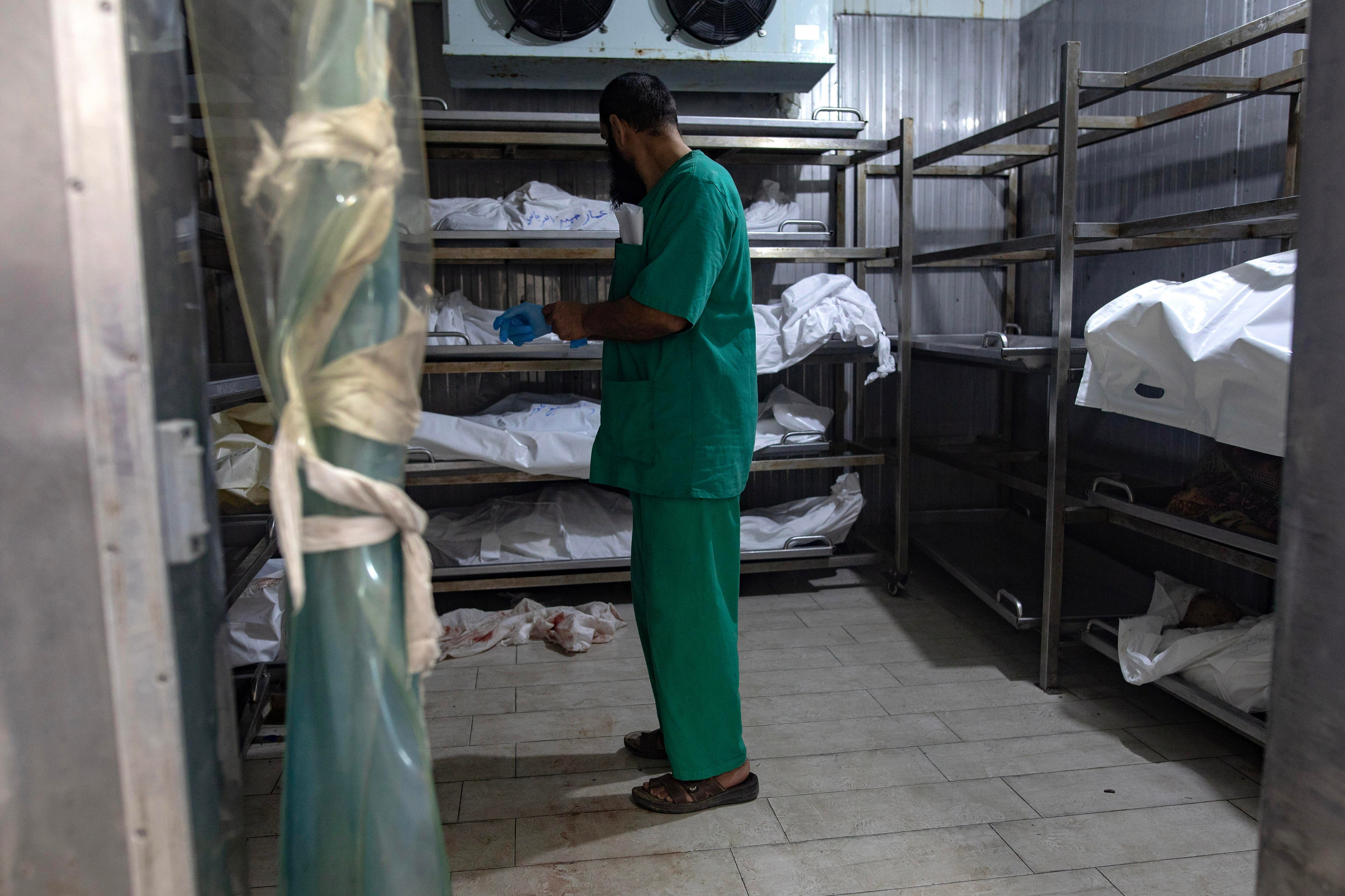 Un trabajador sanitario, junto al cuerpo de varias víctimas de un ataque aéreo de Israel sobre el campo de refugiados de Khan Yunis, esta semana.