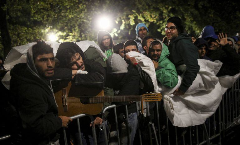 NIE011 BERLÍN (ALEMANIA) 09/10/2015.- Cientos de refugiados aguardan bajo la lluvia y el frío a ser atendidos en la Oficina de Sanidad y Asuntos Sociales en Berlín (Alemania) en la madrugada de hoy, 9 de octubre de 2015. EFE/Kay Nietfeld