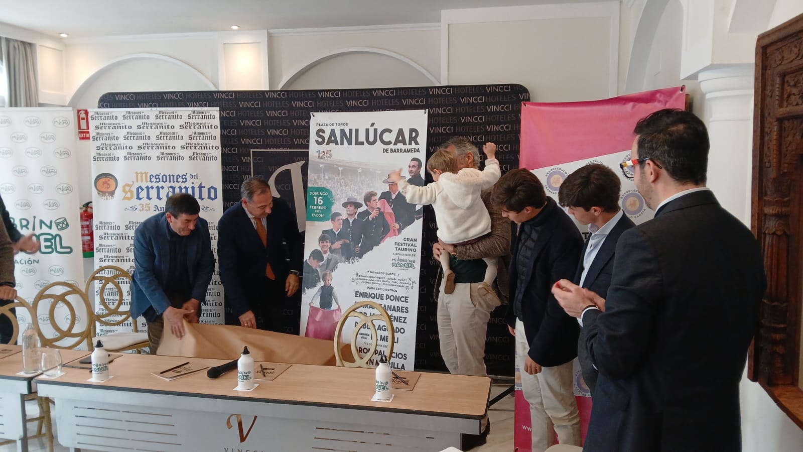 El pequeño Manuel celebra en brazos de su tío Juan Sierra la presentación del cartel de Sanlúcar de Barrameda