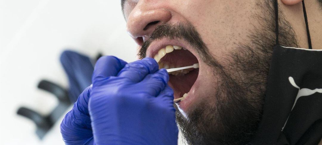 Un sanitario realiza una prueba PCR a un paciente.