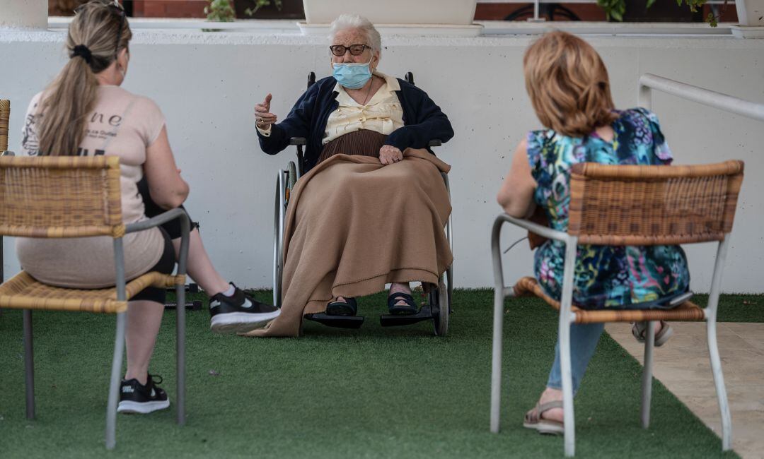 Una anciana recibe la visita de unos familiares en una residencia de PAterna (València)