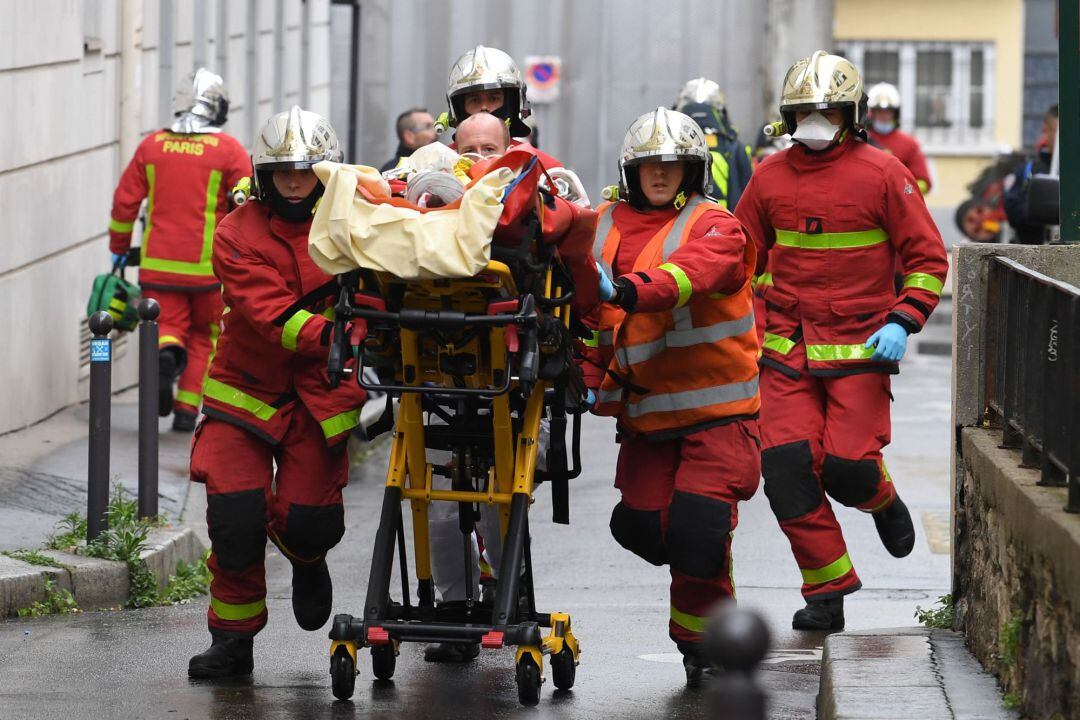 Bomberos franceses trasladan a uno de los heridos en el ataque en París