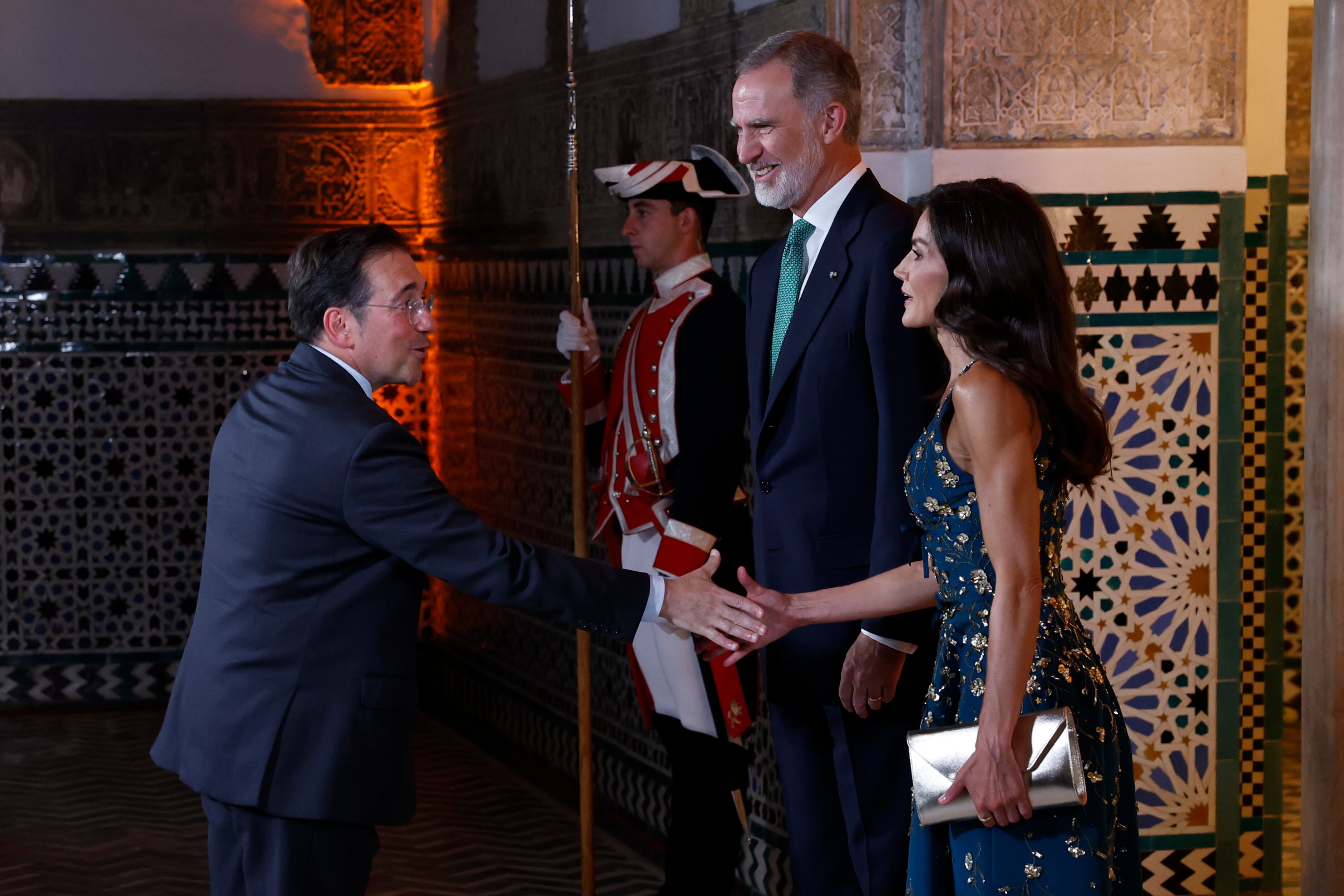 SEVILLA,29/06/2025.- El rey Felipe VI (c) y la reina Letizia reciben al ministro de Asuntos Exteriores español, José Manuel Albares (i), este domingo, momentos antes de la cena de gala que han ofrecido a los líderes mundiales que asisten a la IV Conferencia Internacional sobre Financiación para el Desarrollo. EFE/ EFE/ Mariscal POOL