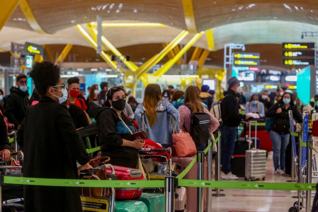 Filas de pasajeros esperan para dejar su maleta antes de embarcar en el avión en la T4 del Aeropuerto Adolfo Suárez Madrid-Barajas