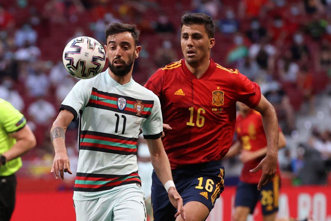 El centrocampista de la selección portuguesa Bruno Fernandes (i) protege un balón ante Rodrigo Hernández, de España, durante el partido amistoso disputado este viernes en el estadio Wanda Metropolitano.