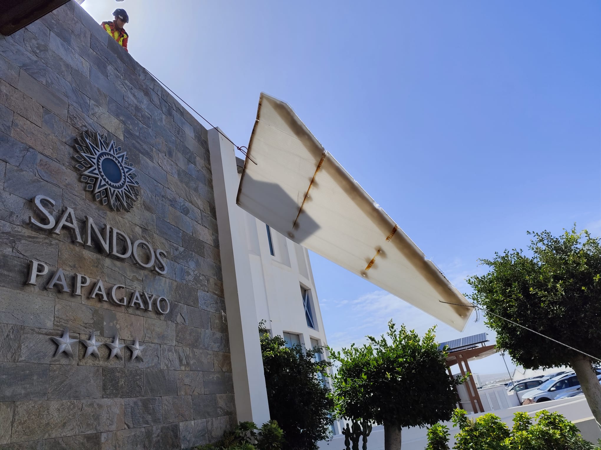 Los bomberos retirando parte de la fachada del hotel Sandos Papagayo Arena de Playa Blanca, en Lanzarote, afectada por el viento.