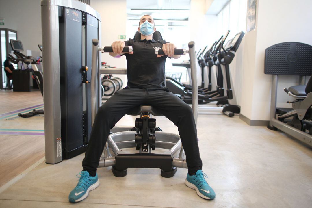 Un monitor de gimnasio entrena tras la reapertura de estos espacios por la pandemia de la COVID-19.