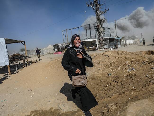 Una dona palestina fuig d'un atac aeri d'Israel a la ciutat de Gaza, ahir dilluns