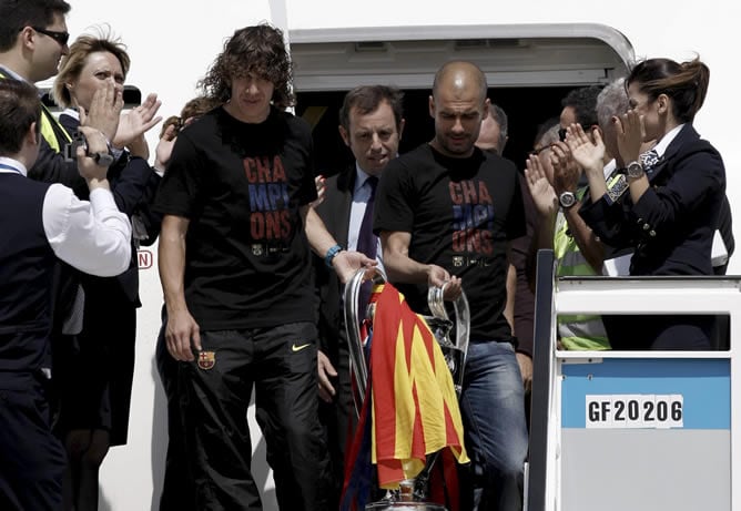 El presidente del FC Barcelona, Sandro Rosell (c); el entrenador, Pep Guardiola (d), y el capitán, Carles Puyol, a su llegada al aeropuerto de Barcelona, donde el conjunto azulgrana celebra esta tarde con los aficionados su victoria en la final de la Liga