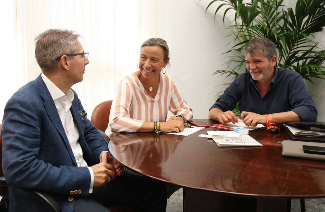 Isabel Albás sonríe con Juan Salado en el transcurso de la reunión