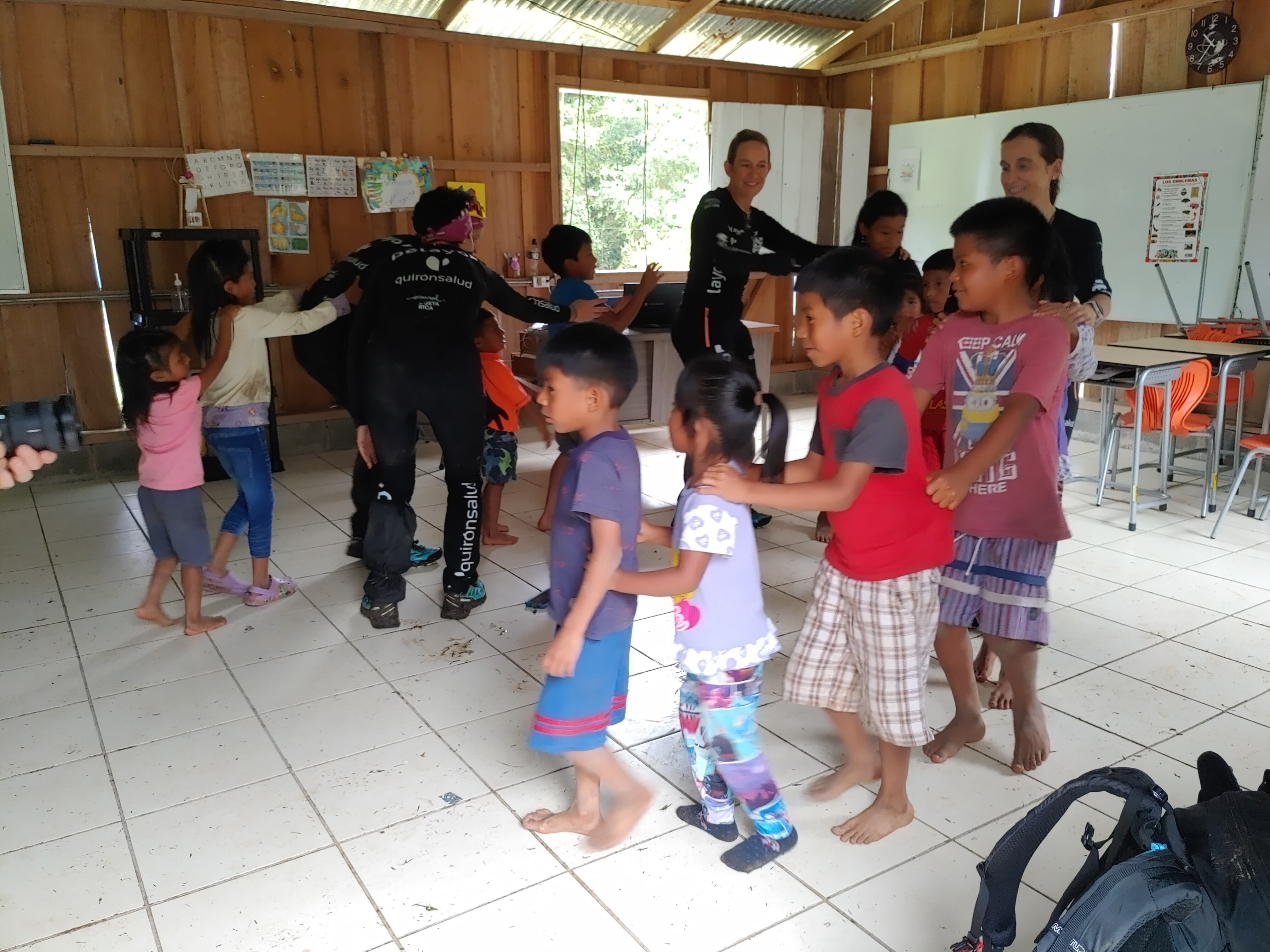 Varios niños jugando con las participantes del Reto Pelayo en la escuela