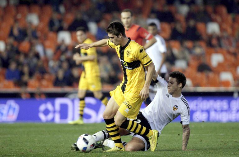 GRA563. Valencia, El delantero del Valencia CF, Santi Mina (d), intenta cortar el avance del centrocampista del Barakaldo, Aitor Ortega, durante el encuentro correspondiente a la vuelta de los dieciseisavos de final de la Copa del Rey, que han disputado esta noche en el estadio valencianista de Mestalla. EFE, Manuel Bruque.