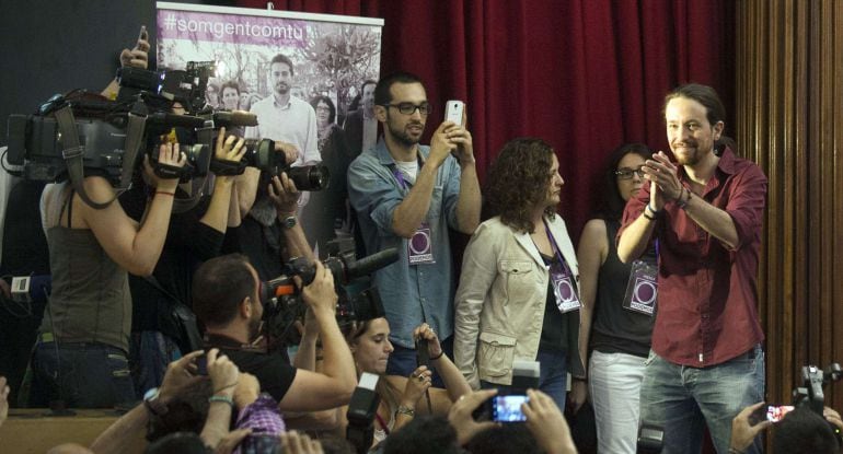 Anti-austerity political party Podemos&#039; leader Pablo Iglesias (R) claps as he arrives at the Valencian University&#039;s Geography and History faculty to take part in a campaign meeting for the regional and municipal election, in Valencia on May 15, 2015. AFP PHOTO / JOSE JORDAN