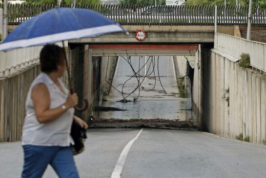 GRA328. SAN VICENTE DEL RASPEIG (ALICANTE), 08/09/2015 .- Una mujer pasa ante un paso subterráneo en San Vicente del Rapeig, localidad limítrofe a Alicante, donde una tromba de agua ha dejado más de 41 litros de lluvia por metro cuadrado en menos de una hora, lo que ha provocado que se aneguen bajos y garages .EFE/MORELL