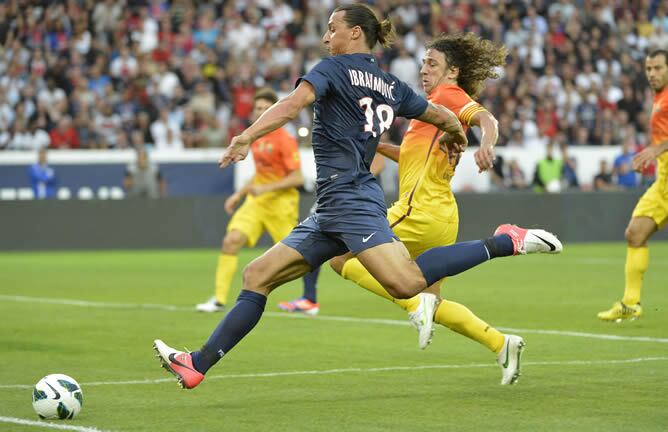 El delantero sueco del Paris Saint-Germain Zlatan Ibrahimovic (i) lucha por el balón con el defensa del FC Barcelona carles Puyol (d) durante su partido amistoso jugado en el estadio Parc des Princes de París