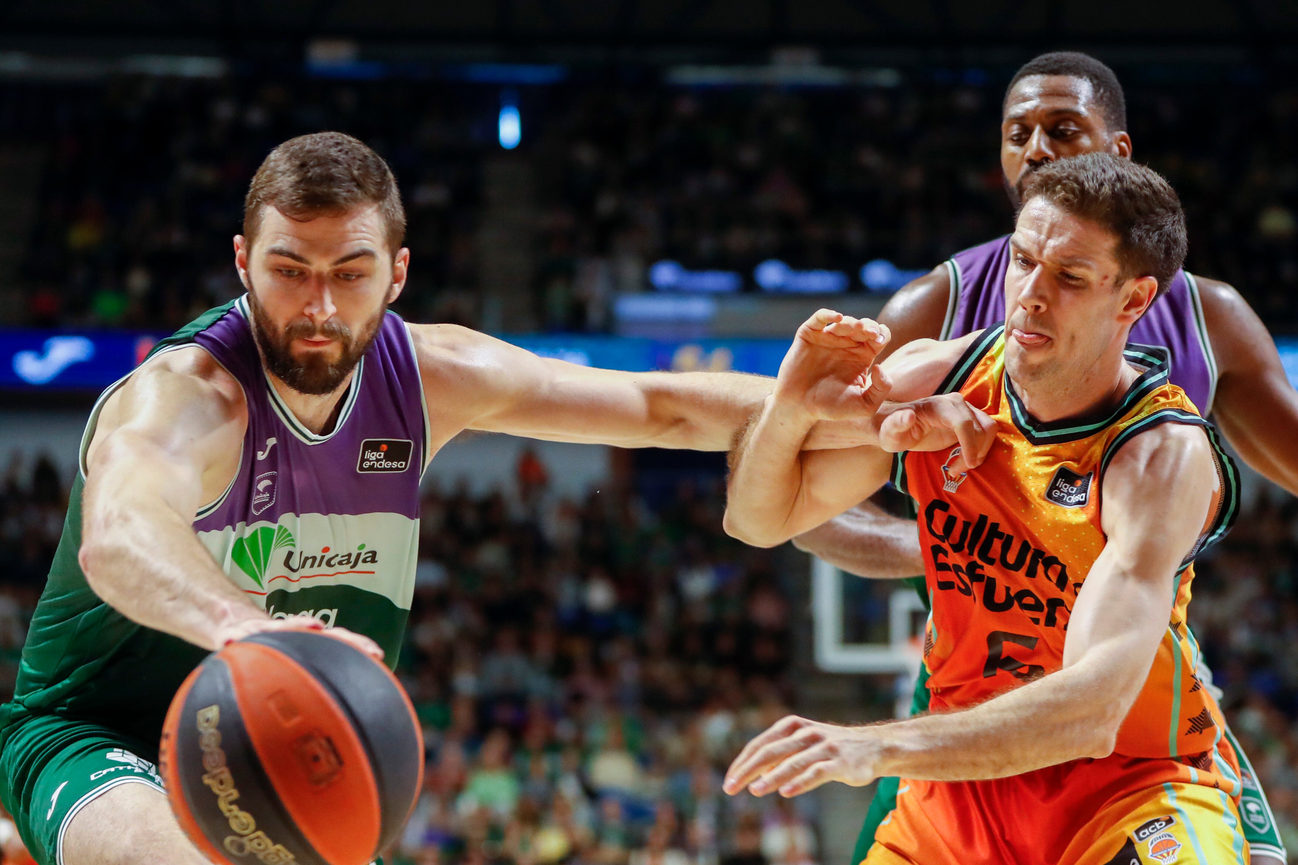 MÁLAGA, 29/01/2023.- El pívot estadounidense del Unicaja, David Kravish (i) lucha por el balón con el alero Xabi Lopez-Arostegu (d) del Valencia Basket durante su partido correspondiente a la Liga ACB disputado en el pabellón Martín Carpena de Málaga este domingo. EFE/ Jorge Zapata