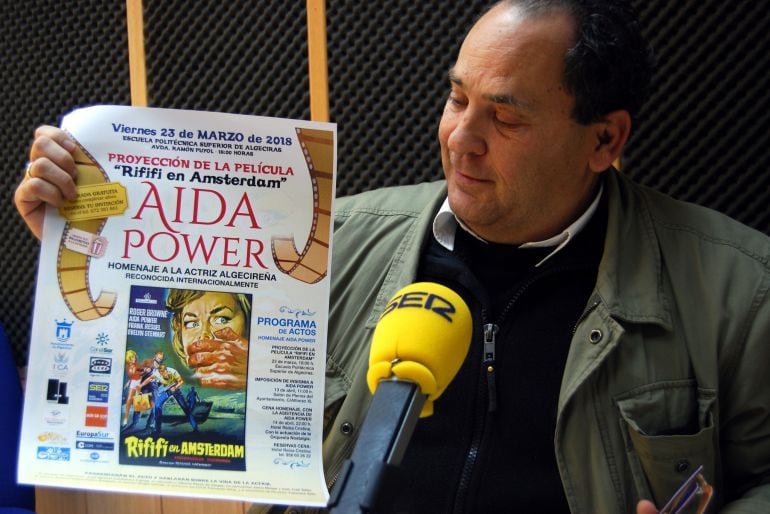 Javier Ortega, promotor del homenaje a Aida Power, sujeta un cartel anunciador de la proyección de la película "Rififi en Amsterdam".