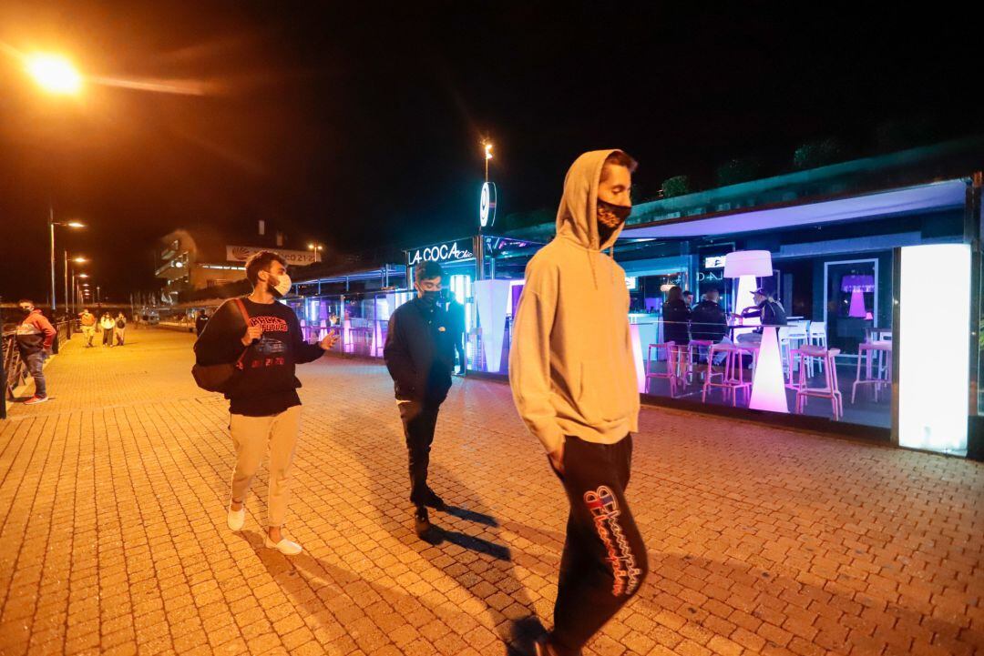 Jóvenes pasean por una zona de locales de ocio nocturno,