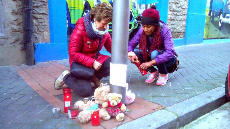 Dos mujeres dejan velas en el lugar en el que Alicia fue arrojada al vacío en Vitoria 