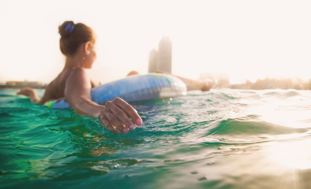 Una persona nadando en la playa.