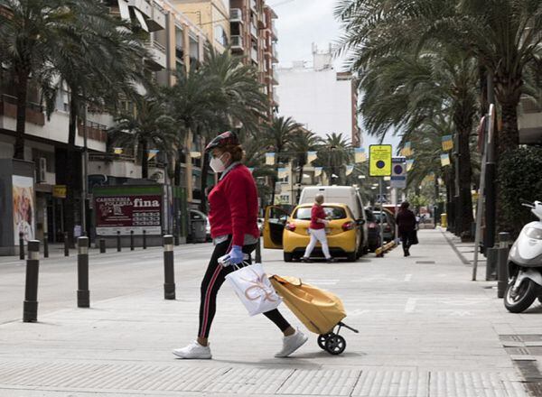 Gente con mascarilla y guantes en las calles de gandia