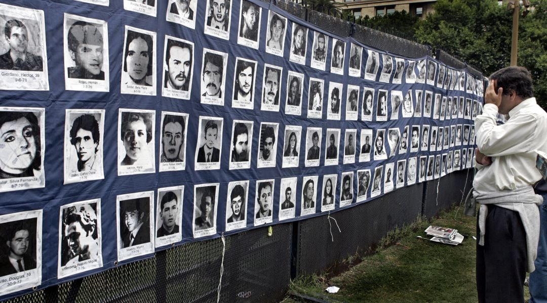 Hombre mirando las fotos de los desaparecidos durante la dictadura argentina de Videla