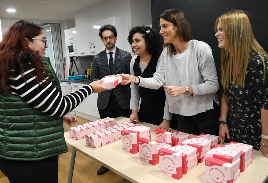 Membres del Govern lliurant a una dona un dels lots de productes menstruals gratuïts en el marc d&#039;una campanya de reducció de residus.