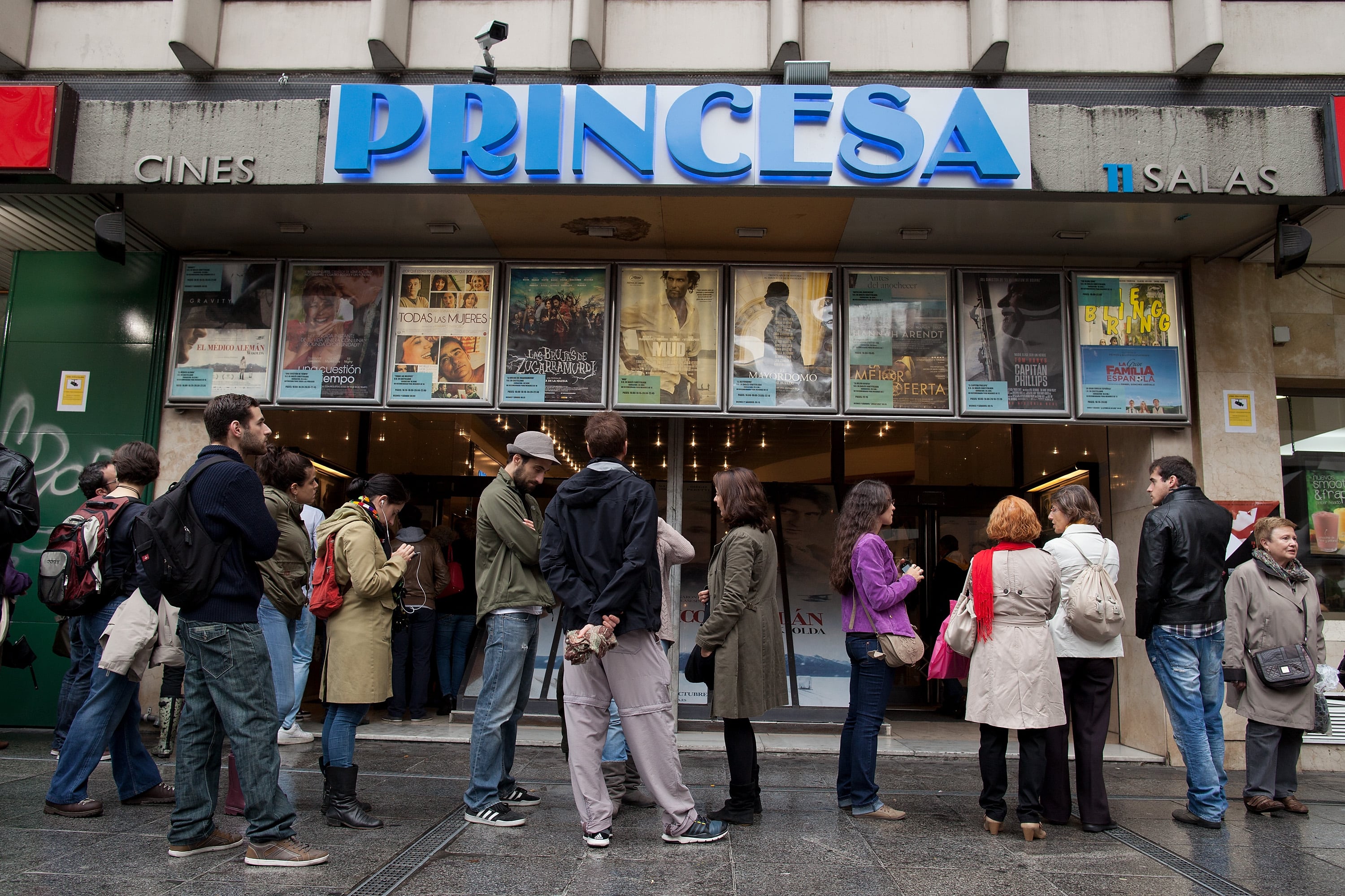 Varias personas esperan en la entrada de los cines Princesa durante la Fiesta del Cine.