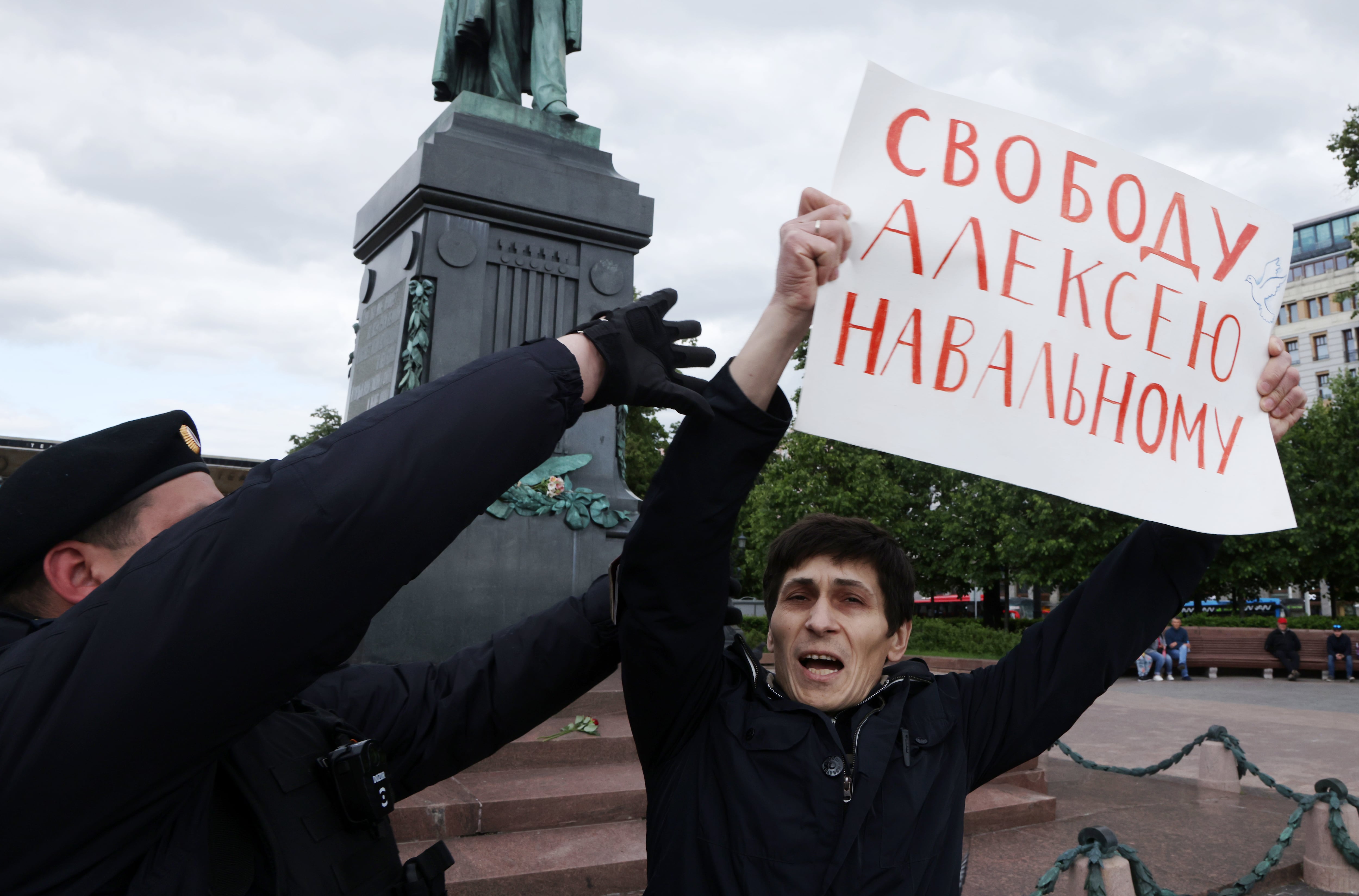 Un agente intenta detener a un hombre que sujeta un cartel en el que se lee &quot;Libertad para Alexei Navalny&quot; en Moscú