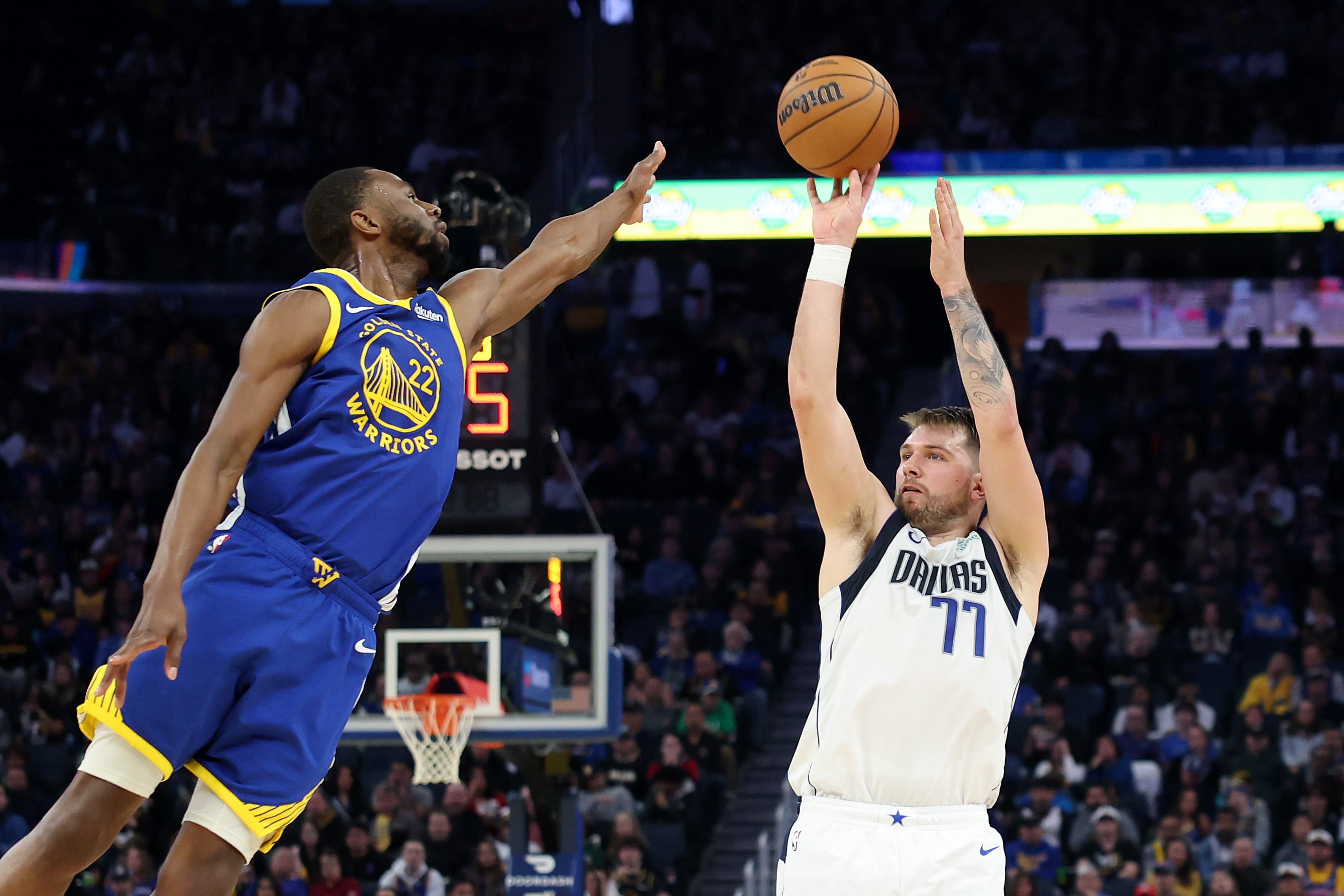 Luka Doncic anota ante Andrew Wiggins en el duelo entre Golden State Warriors y Dallas Mavericks