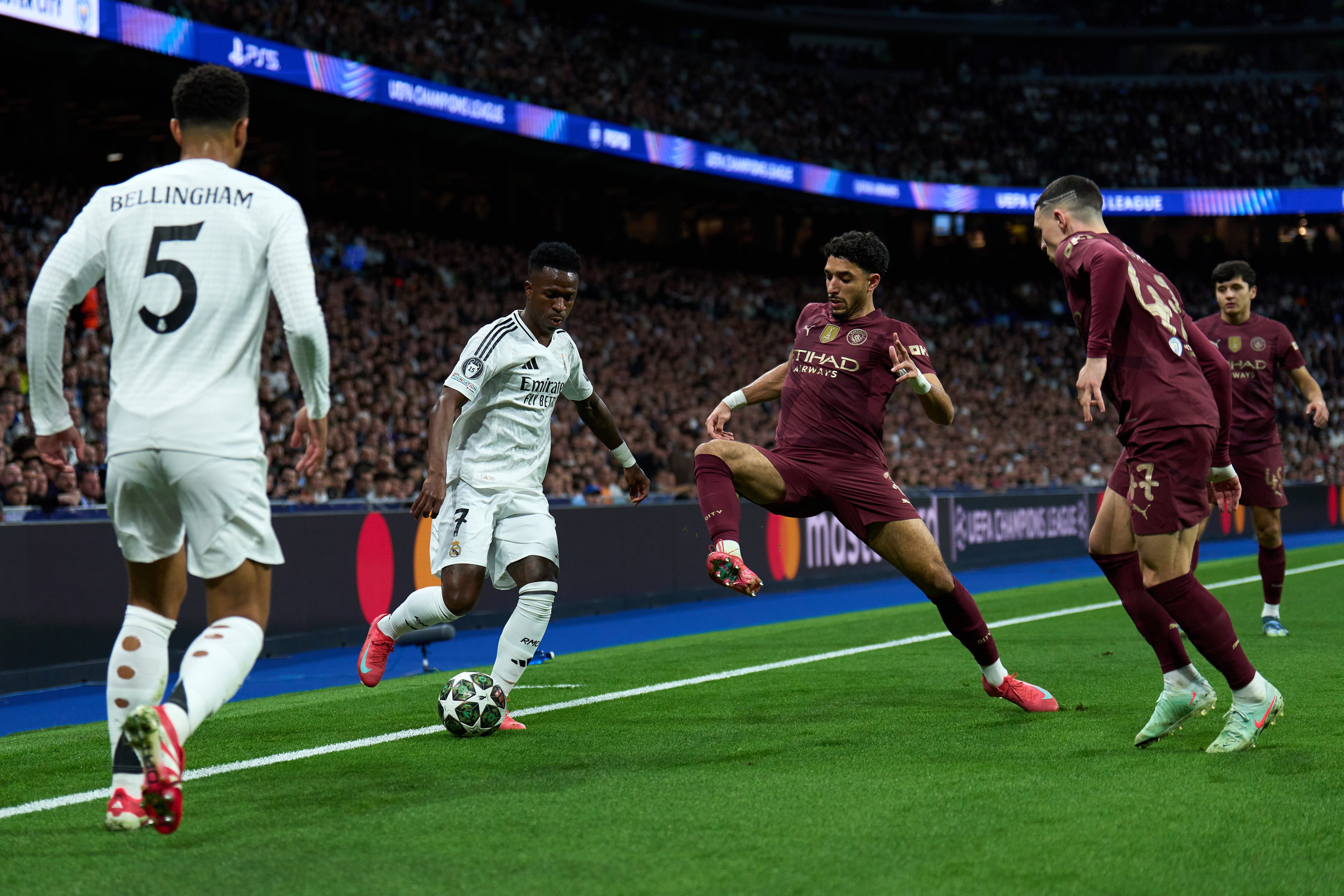 MADRID, SPAIN - FEBRUARY 19: Vinicius Junior of Real Madrid is challenged by Omar Marmoush of Manchester City during the UEFA Champions League 2024/25 League Knockout Play-off second leg match between Real Madrid C.F. and Manchester City at  on February 19, 2025 in Madrid, Spain. (Photo by Angel Martinez/Getty Images)