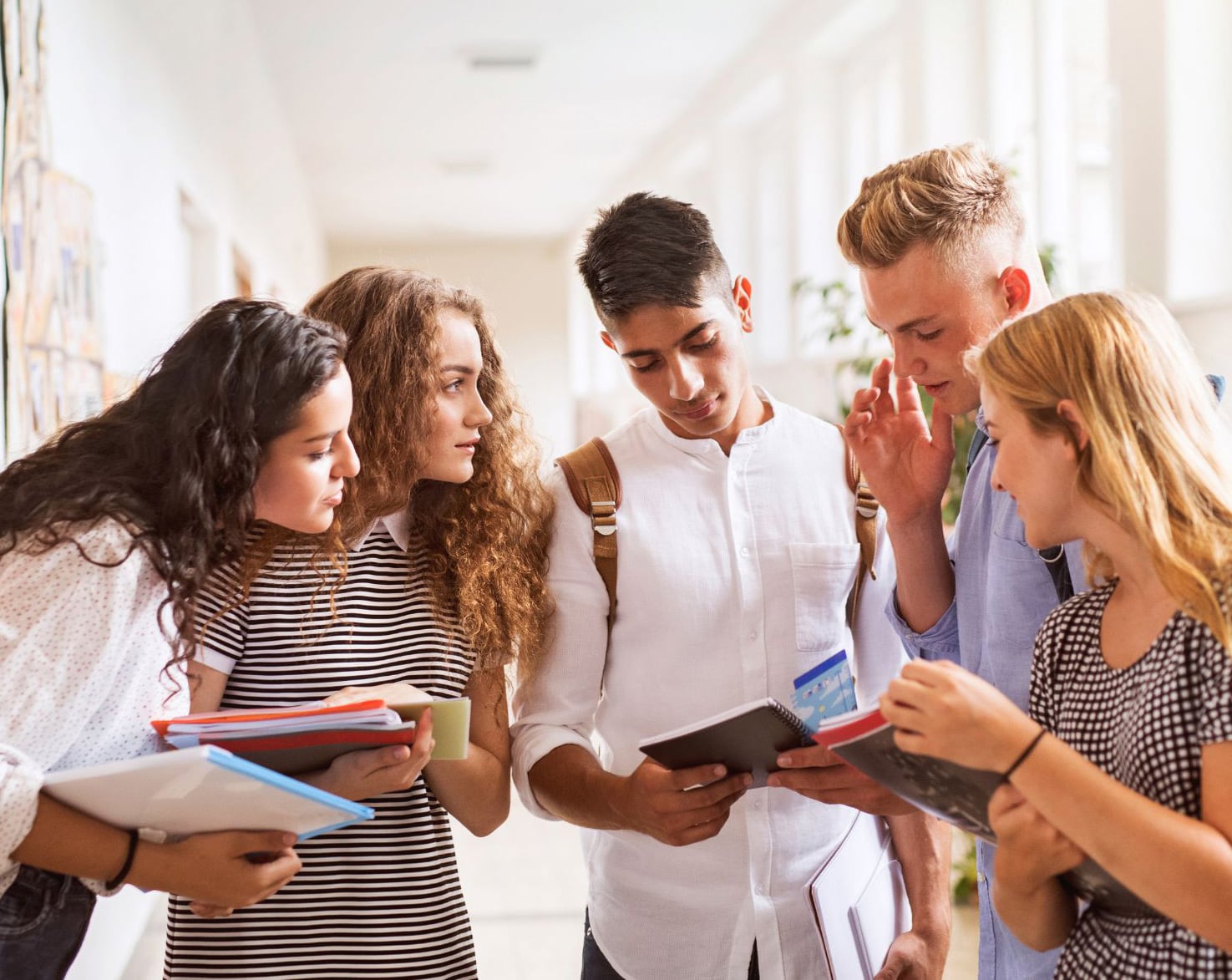 Grupo de jóvenes consultando sus apuntes