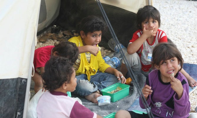 Niños refugiados sirios comiendo su almuerzo en el campamento de refugiados de Za&#039;atri en Mafraq