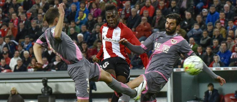 El jugador del Athletic de Bilbao Iñaki Williams (c) chuta para marcar ante el Rayo Vallecano, durante el partido de Liga en Primera División que están disputando esta noche en el estadio de San Mamés, en Bilbao