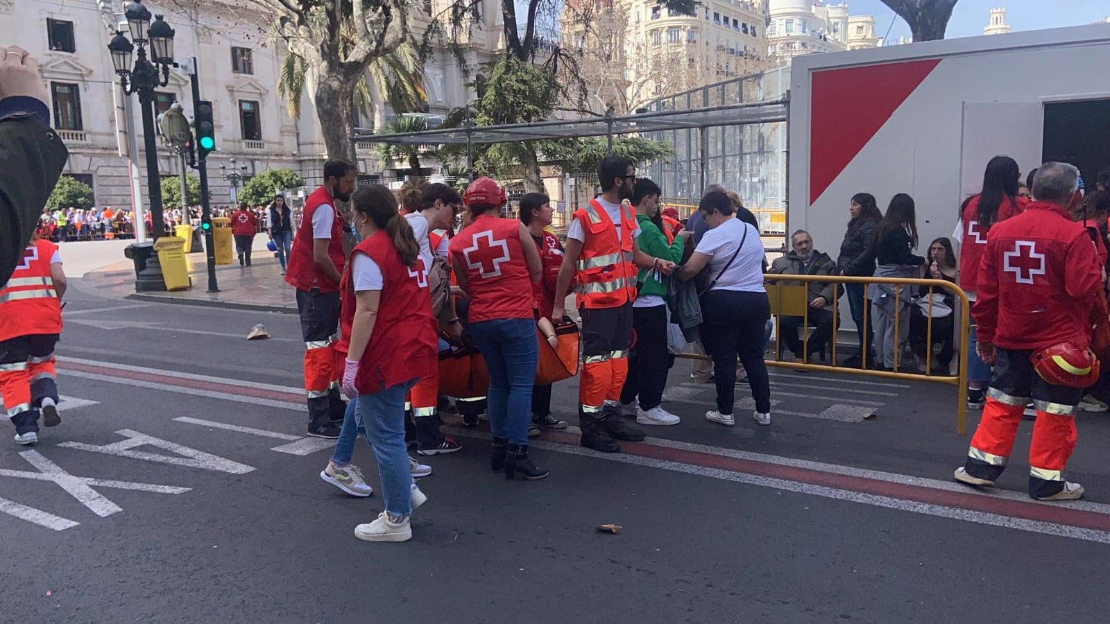 Efectivos de Cruz Roja atienden a una persona con una lipotimia en las Fallas 2023, en València.