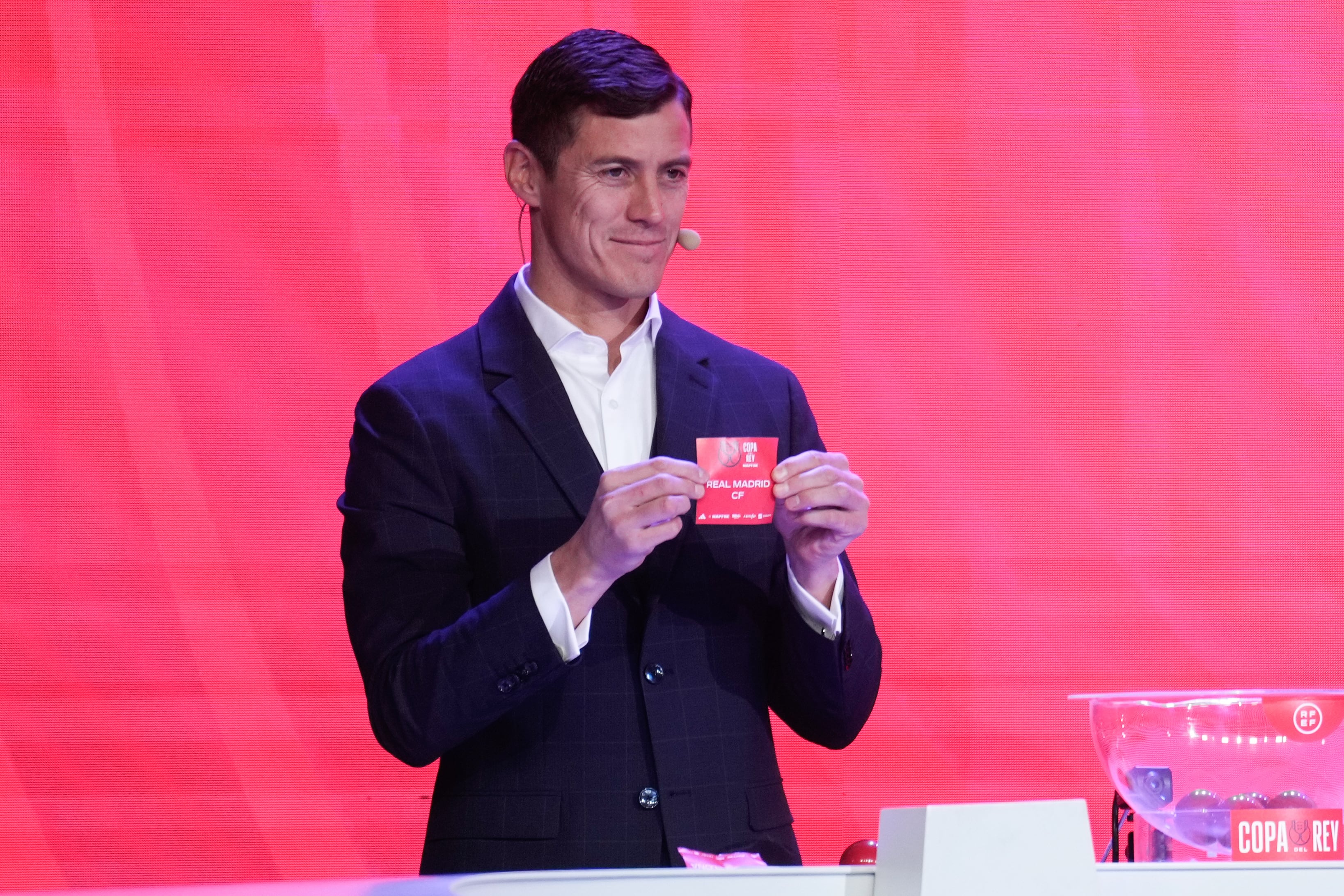 El exfutbolista argentino Martín Mantovani despliega la papeleta del Real Madrid durante el sorteo de los cuartos de final de la Copa del Rey celebrado este lunes en la Ciudad del Fútbol de las Rozas (Madrid).