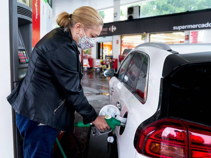 Una mujer echa gasolina a su coche